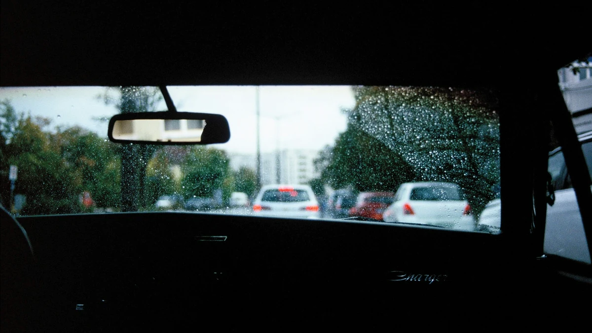 Visão a partir do interior do veículo através do para-brisa molhado pela chuva no trânsito